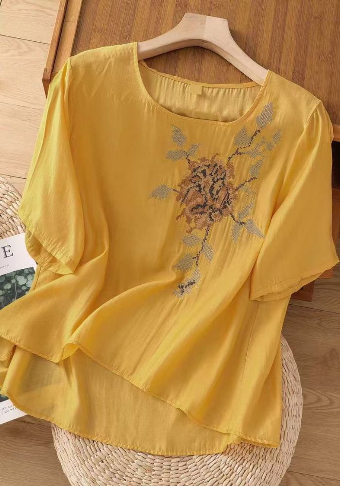 Close-up of floral embroidery detail on women's tunic top